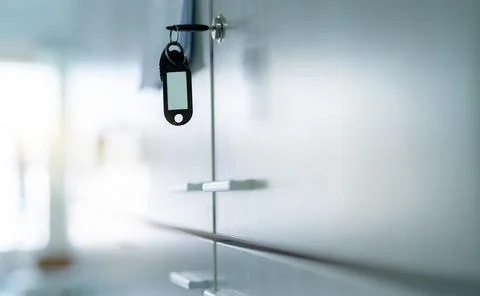 Locker with key and empty key tag in office. Filing cabinet lock with key for 스톡 사진