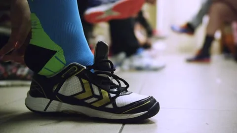 In the locker room, an athlete is putting on their shoes. Stock Footage 286030990