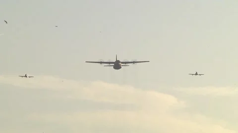 Lockheed C-130 Hercules escorted by 2 fighter jets flying over the airspace Stock Footage 146520213
