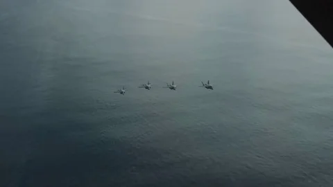 Lockheed Martin F-35 Lightning II 4 attack aircraft fly over the ocean Stock Footage 121798525