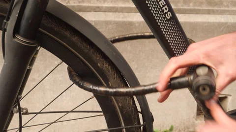 Locking a bicycle. Close up of bike, hands and lock. Stock Footage 190531807