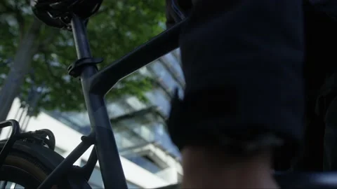 Locking up a bicycle in front of inner city building Stock Footage 132708280