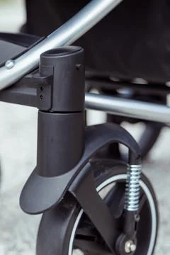Locking button on the front wheels in a baby stroller. Stock Photos