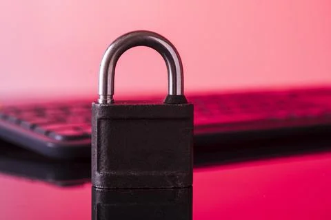 Locking the computer keyboard. The lock and keypad are tinted red. Informatio Stock Photos