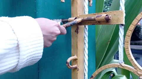 Locking a fence door with hand Stock Footage 146254517