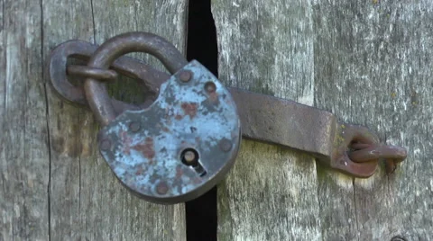 Locking Unlocking  padlock an old rustic door Stock Footage 55033381