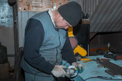 Locksmith assembler process the part with a grinder 스톡 사진