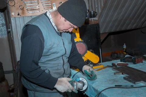 Locksmith assembler process the part with a grinder 写真素材