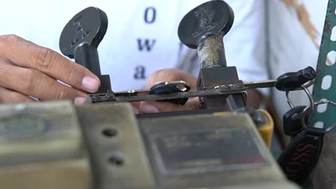 A locksmith create a duplicate of a motorcycle key in Jakarta, Indonesia Stock Footage 211577508