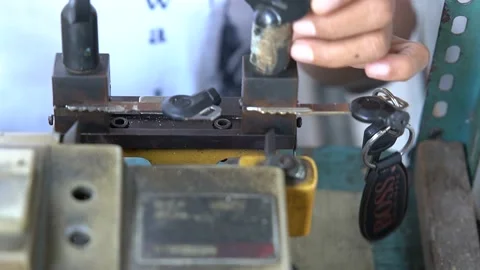 A locksmith create a duplicate of a motorcycle key in Jakarta, Indonesia Stock Footage 211577655