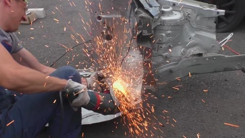 A locksmith cuts out a metal part of a car body with a tool. Stock Footage 158976693