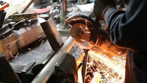A locksmith cuts a piece of pipe with a cutting machine Stock Footage 145847604