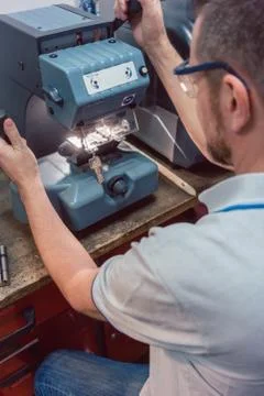 Locksmith cutting key with his machine 스톡 사진
