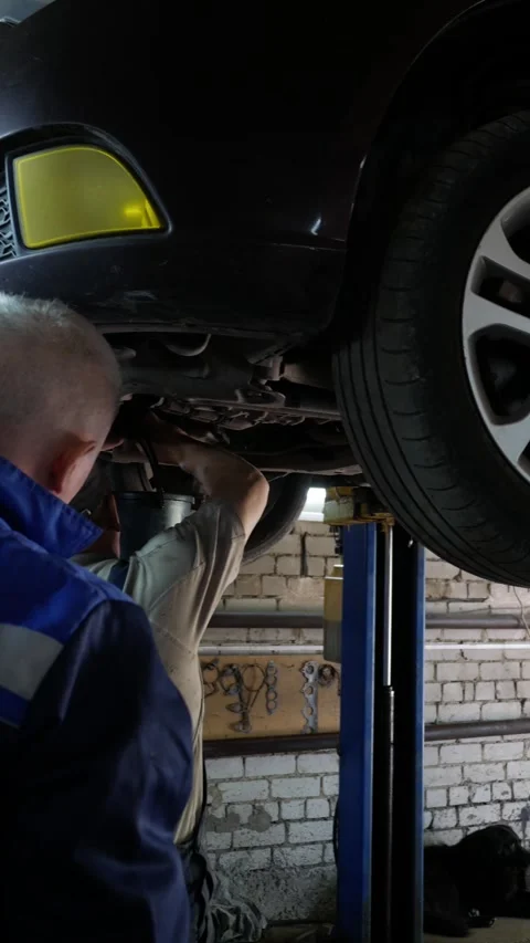 Locksmith drains from the car engine oil. Car service. Vertical format. Unrecogn Stock Footage 276681578