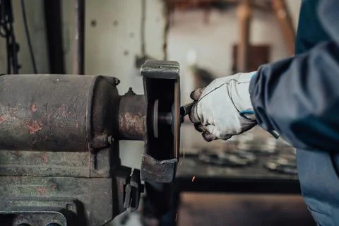 A locksmith grinding pieces of iron on a machine Stock Photos