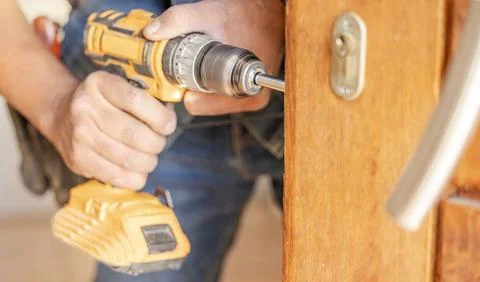 Locksmith hands, maintenance and handyman with construction and fixing, change Stock Photos