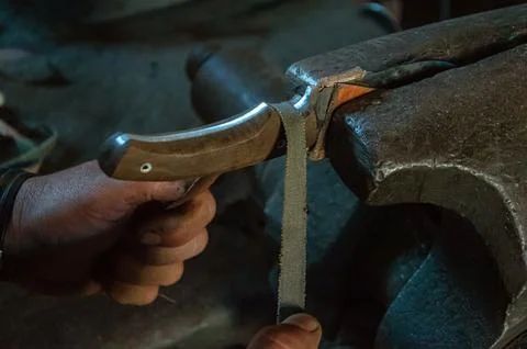 Locksmith hands manufacturing a knife held in the vise Stock Photos