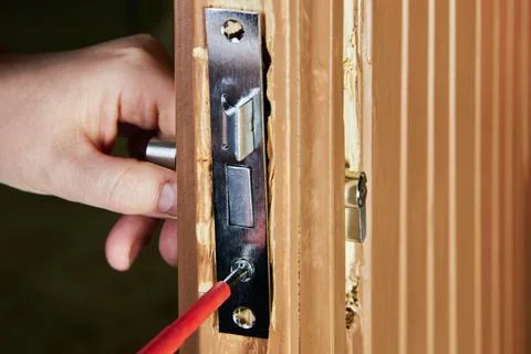 Locksmith inserts framework of mortise door lock into groove or pocket cut .. Stock-Fotos