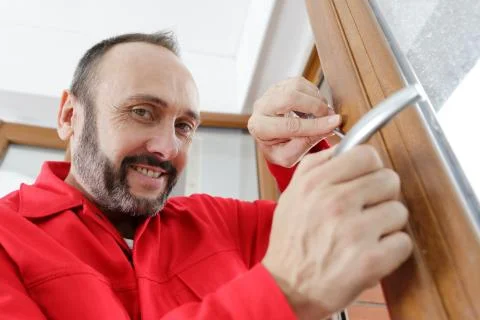 Locksmith man try to fix knob on wood door Stock Photos