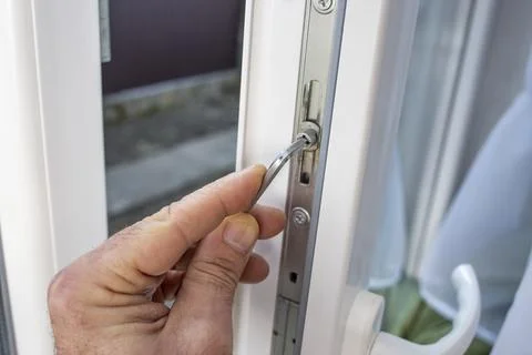 Locksmith opened and adjusting for winter with a screwdriver the lock mecha.. Stock Photos