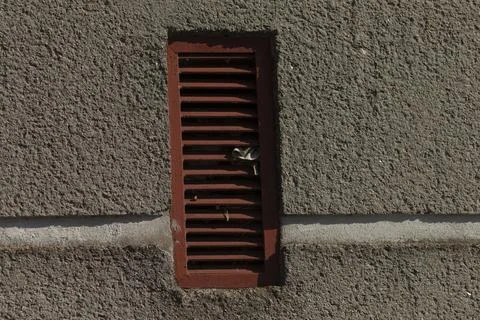 Locksmith or technician inspecting keylocked vent on textured wall Stock Photos