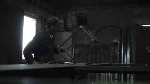 Locksmith in special clothes and goggles works in the workshop. He inspects the Stock Footage 135746397