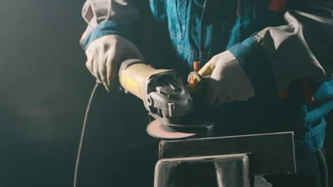 Locksmith in special clothes and goggles works in production. Metal processing Stock Footage 145154286