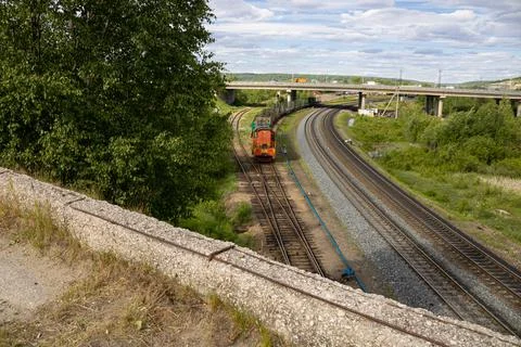 Locomotive and freight train pulls away from the station Stock Photos