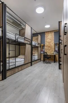 Loft hostel dormitory with industrial elements and wooden bunk beds 스톡 사진