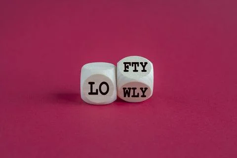 Lofty or lowly symbol. Concept words Lofty Lowly on wooden block. Foto stock