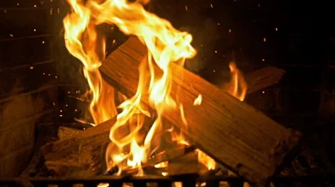 Log being thrown onto fire in slow motion. Embers rising Stock Footage 46100992