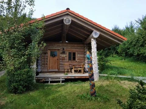 Log cabin behind tree spotted in Germany Stock Photos