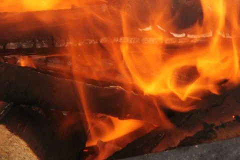Log in the flames. burning fire in the grill is large. Stock Photos
