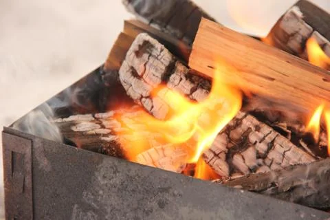 Log in the flames. burning fire in the grill is large. Stock Photos