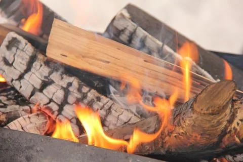 Log in the flames. burning fire in the grill is large. Stock Photos