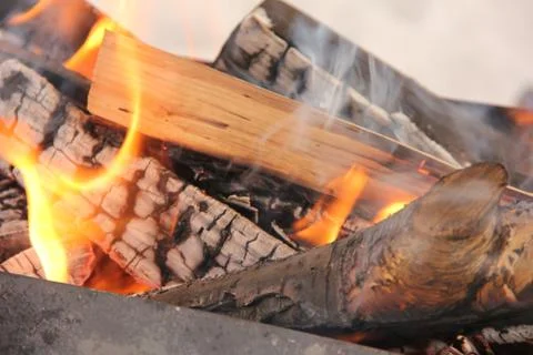 Log in the flames. burning fire in the grill is large. Stock Photos