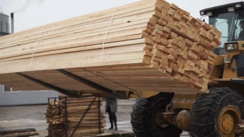 A log grapple getting lots of trunks and piling up outside the sawmill factory Stock Footage 78012102