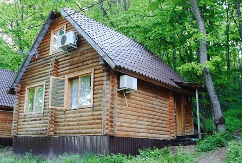 The log house is located in the forest Stock Photos