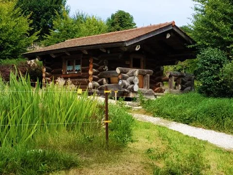 Log house surrounded by beatuiful green garden Stock Photos