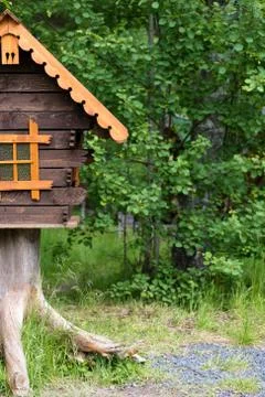 Log hut in the park on a background of trees Stock Photos
