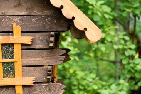 Log hut in the park on a background of trees Stock Photos
