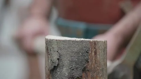 Log split with a DOLABRA by a Roman soldier blowing up chips and sawdust Stock Footage 147623481