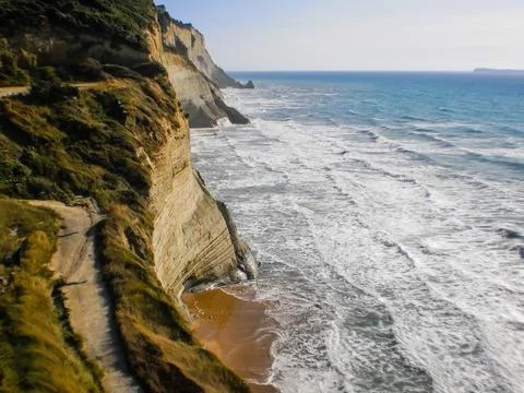 Loggas Beach cliffs and waves in Peroulades, Corfu, Greece. Stock Photos