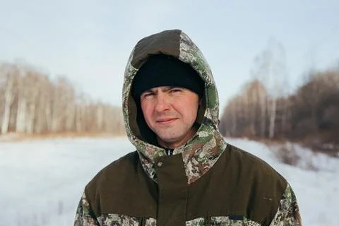 A logger saws a tree in the forest in winter, in Russia for firewood Stock Photos