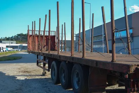 A logging truck with empty trailers drives forward along the highway agains.. Stock Photos