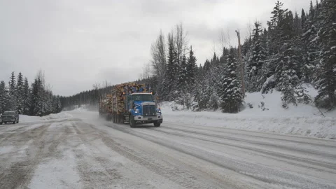 Logging truck, loaded, passing by on a snowy mountain road, 4k Stock Footage 169901375