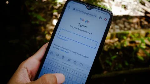 Login page of "Google Account" in android browser. Asian man's hand is typing. Foto stock