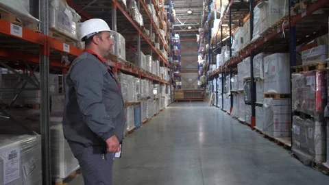 At the logistic warehouse, the worker looks at the boxes, writes notes. 4K Slow Video stock 111767652