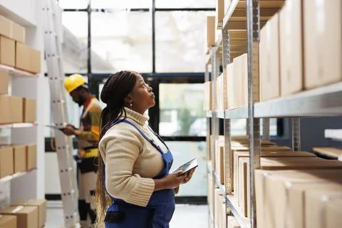 Logistics and distribution manager inspecting merchandise storage in warehouse Stock Photos