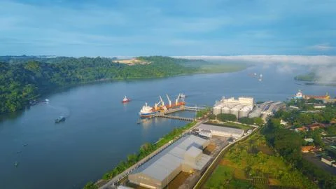 Logistics Cargo Ship Unloading at Cilacap Port with Nusakambangan Island Foto stock